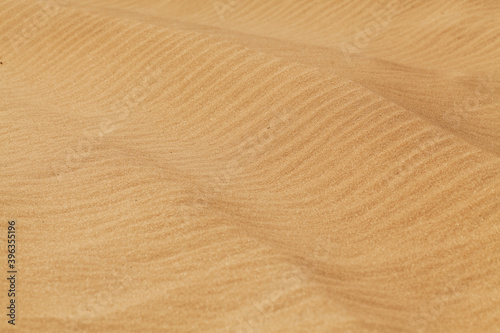 Yellow desert sand with diagonal wave patern.