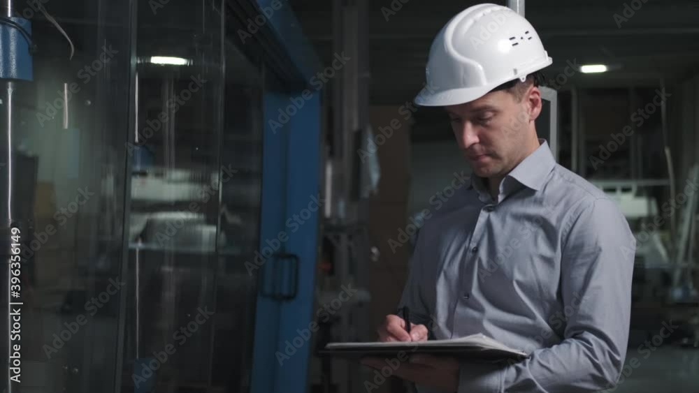 Man engineer with helmet in Industrial environment using tablet Man engineer with helmet in Industrial environment using tablet