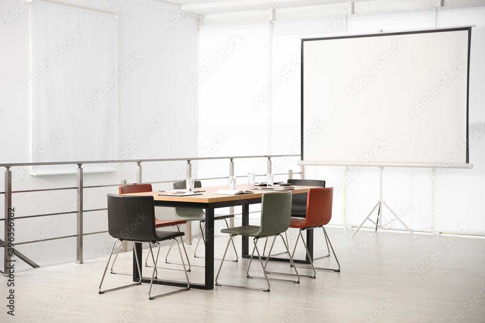 Modern meeting room interior with large table and projection screen Modern meeting room interior with large table and projection screen
