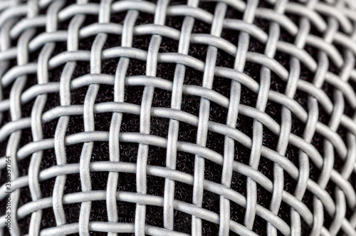 Simple silver microphone grill background texture, macro, extreme closeup. Mic metal grate mesh musical backdrop Karaoke, singing, studio recording, music equipment themed abstract backgrounds concept © Tomasz