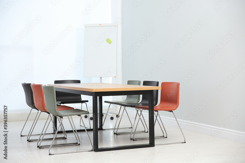 Conference room interior with wooden table and flipchart