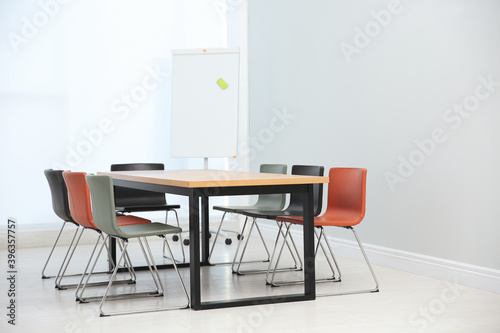 Conference room interior with wooden table and flipchart