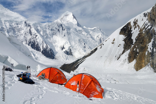 Orange tents (mountain climbers camp) against Khan Tengri peak (7010 m), Central Tian Shan, China - Kyrgyzstan - Kazakhstan.