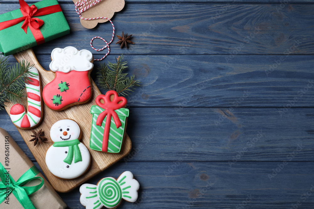 Decorated Christmas cookies on blue wooden table, flat lay. Space for text