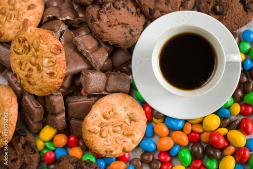 Cup of black espresso coffee and chocolate, candy and cookies