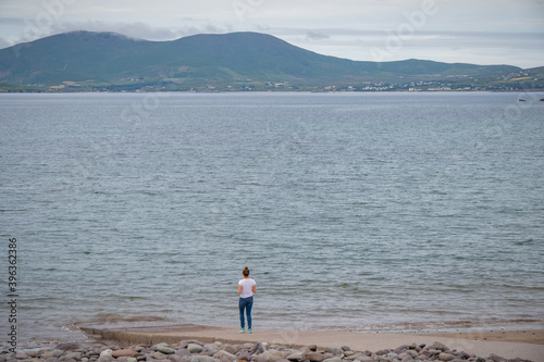 Amazing panoramic view of Scarriff Island, Ring of Kerry, Iveragh Peninsula, County Kerry, Ireland, Europe. Part of Wild Atlantic Way. Young girl looking at horizon from shore.