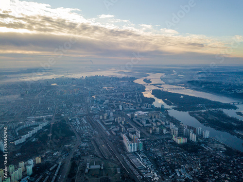 Aerial high flight over Kiev, haze over the city. Autumn morning, the Dnieper River is visible on the horizon.