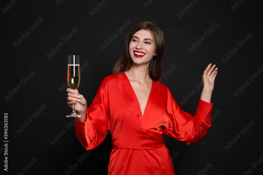 Happy woman with glass of champagne on black background. Christmas party Happy woman with glass of champagne on black background. Christmas party