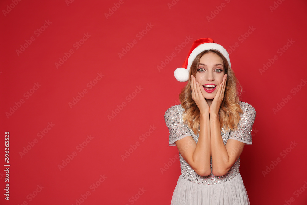 Emotional woman in Santa hat on red background, space for text. Christmas party Emotional woman in Santa hat on red background, space for text. Christmas party