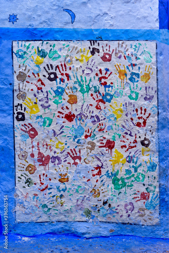 mains colorées peintes sur un mur 