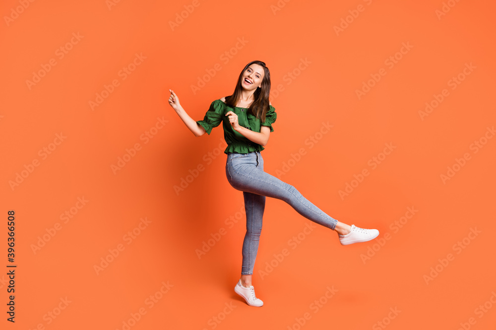 Full length photo of cute adorable lady wear green off-shoulders blouse dancing isolated orange color background