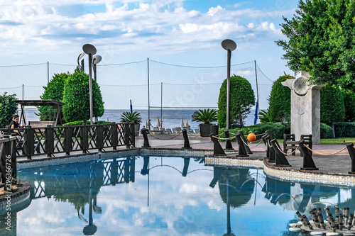 Turkey, Alanya - October 22, 2020: Pool in a public park against the background of Kleopatra Beach and the Mediterranean Sea in Alanya. Reflection of the blue sky in the water in the garden