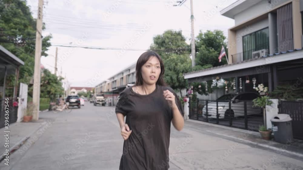 asian young female running alone in font of home neighborhood street, work out motivation, sweating shirt, losing weight body conditioning exercise, on diet weight control, slow motion asian young female running alone in font of home neighborhood street, work out motivation, sweating shirt, losing weight body conditioning exercise, on diet weight control, slow motion
