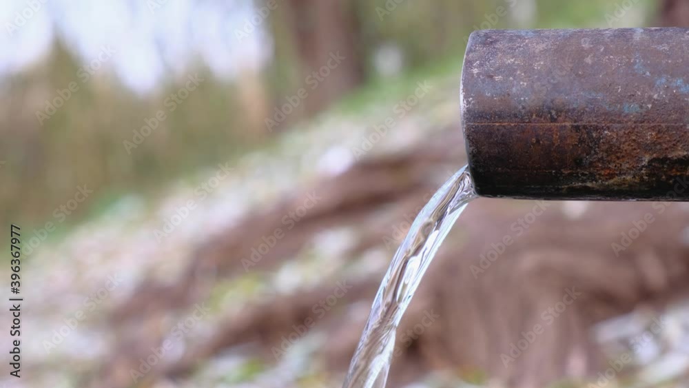 Spring water flowing from a pipe in a park at autumn day. Spring water flowing from a pipe in a park at autumn day.