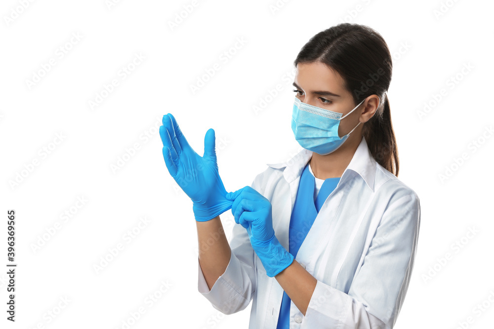 Doctor in protective mask putting on medical gloves against white background Doctor in protective mask putting on medical gloves against white background
