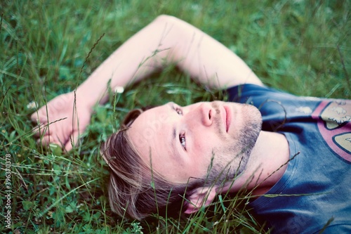 Young man ling down o the grass thinking in new idea with open eyes