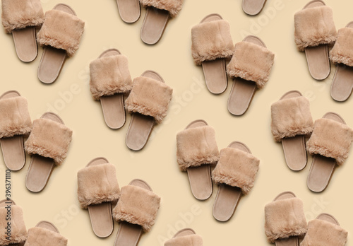 Soft slippers on beige background, top view. Pattern design