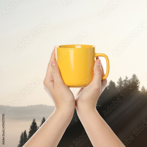 Closeness to nature. Woman holding cup in mountains, closeup