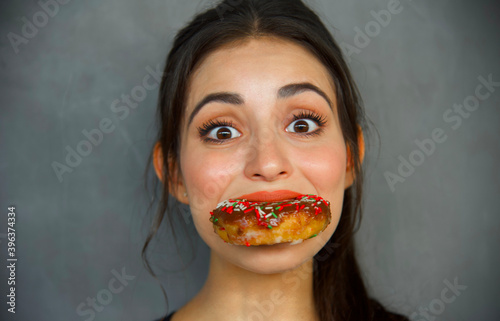 Woman taking a big bite of a chocolate chip donut