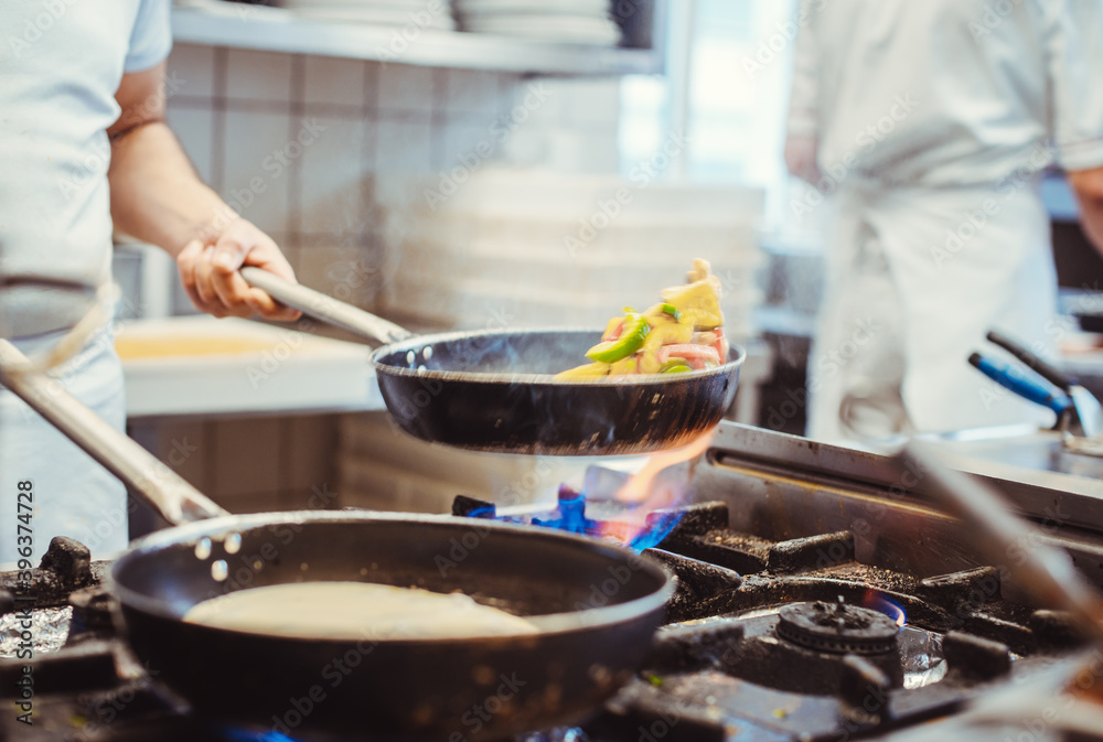 Chef cooking in a restaurant kitchen Chef cooking in a restaurant kitchen