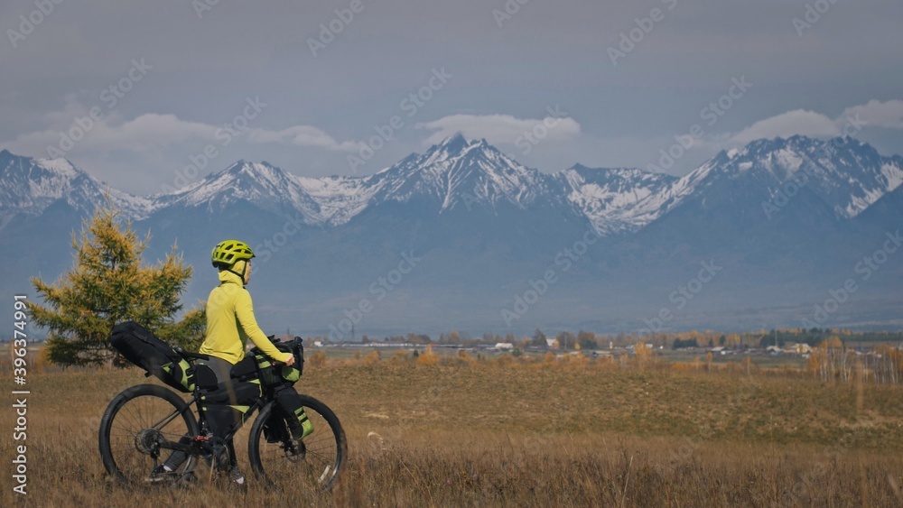 The woman travel on mixed terrain cycle touring with bikepacking. The traveler journey with bicycle bags. Sport tourism bikepacking.