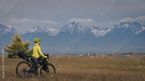 The woman travel on mixed terrain cycle touring with bikepacking. The traveler journey with bicycle bags. Sport tourism bikepacking.