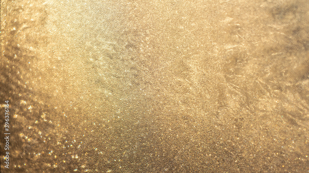 Blurred Golden sunset through frosty pattern on glass window. Shining glowing textured background for graphic design and wallpaper. Blurred Golden sunset through frosty pattern on glass window. Shining glowing textured background for graphic design and wallpaper.