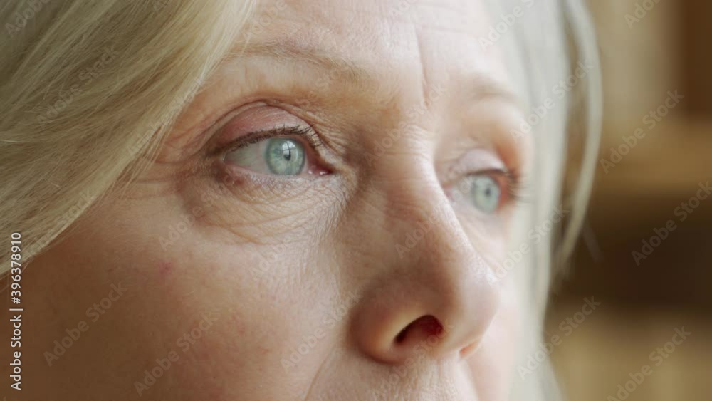 The face and eyes of the old woman. Large wrinkles on the old woman's face. Face close up