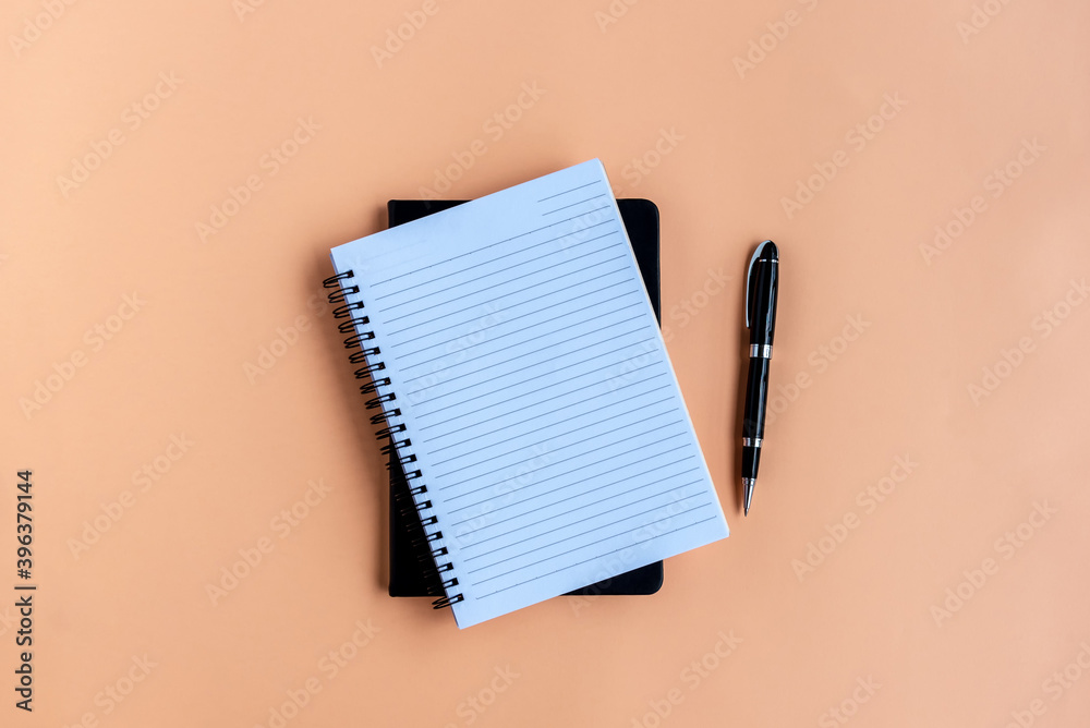 Notepad and pen on colored background with pen Notepad and pen on colored background with pen