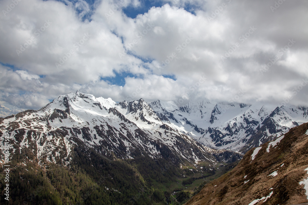 High in the Alps. Snow-capped mountain slopes. Low clouds in the lowlands of the forest.