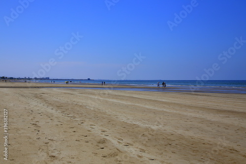 The large beach of Qurum, with unrecognizable walking people, Muscat, Oman