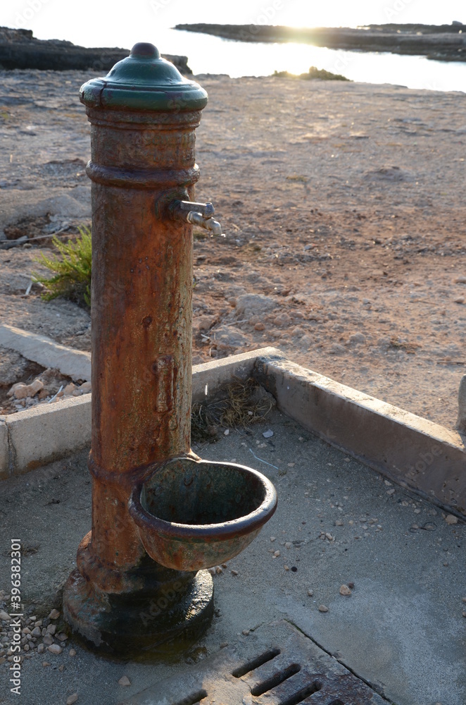 Old water dispenser in Puglia. Covered by rust, called Old water dispenser in Puglia. Covered by rust, called
