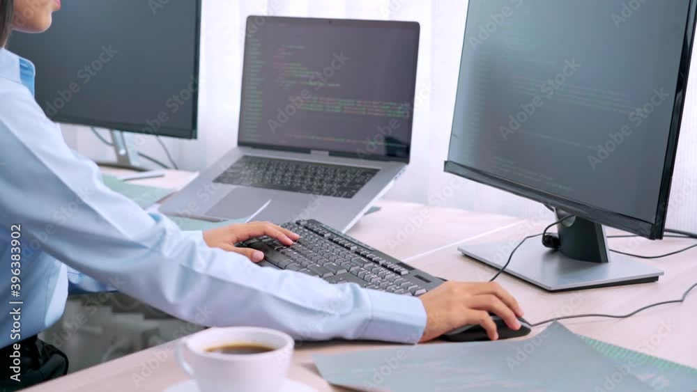 Asian woman programmer typing source code with computer pc for Developing program or application in her office Asian woman programmer typing source code with computer pc for Developing program or application in her office