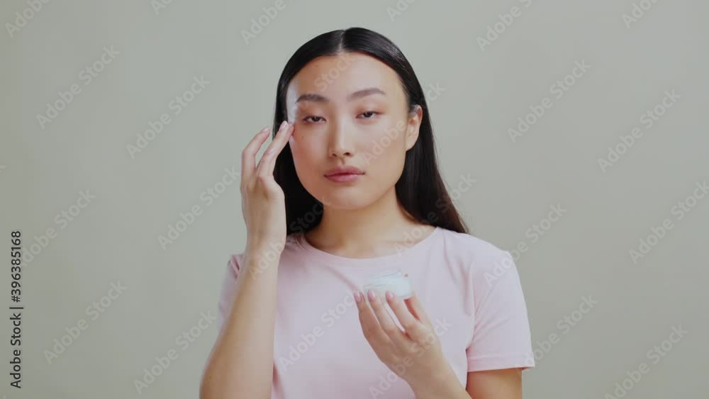 Skincare. Asian beauty. Young chinese woman touching face sking applying moisturizing cream for deep hydration. Selfcare morning routine. Ethnicity. Skincare. Asian beauty. Young chinese woman touching face sking applying moisturizing cream for deep hydration. Selfcare morning routine. Ethnicity.