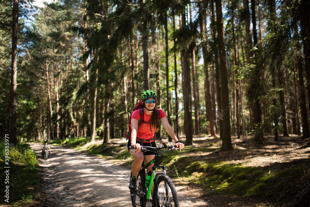 Young woman with helmet riding mountain bicycle in the forest. Young woman with helmet riding mountain bicycle in the forest.