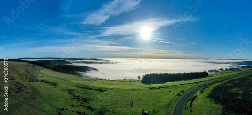 Beautiful morning of drone footage overlooking welsh sceneray with fog sheet covering the lower valleys in south wales uk.
