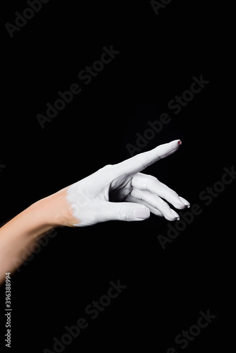 partial view of white painted hand isolated on black, stock image