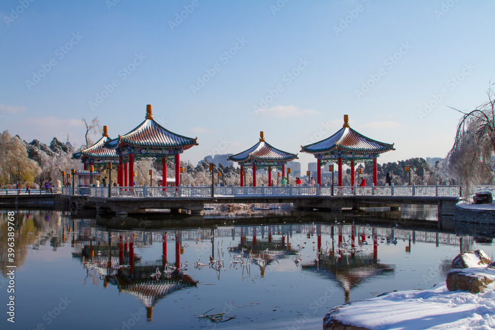 A Chinese Architecture pavilion reflected in lake after storm. Winter landscape. A Chinese Architecture pavilion reflected in lake after storm. Winter landscape.
