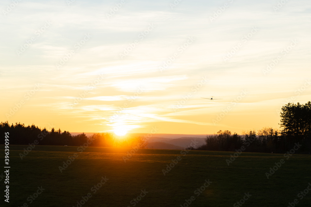 Sonnenuntergang mit Flugzeug im Anflug