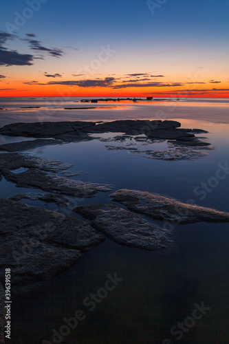 Rocks and stones in the shallow water. Baltic sea shoreline. Late summer sunset, Long exposure.