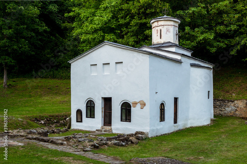 An old Serbian Orthodox monastery of the Holy Trinity in Knjazevac municipality, eastern Serbia. Monastery and churchyard surrounded by green forest. Donja Kamenica, Serbia - 11.28.2020 photo