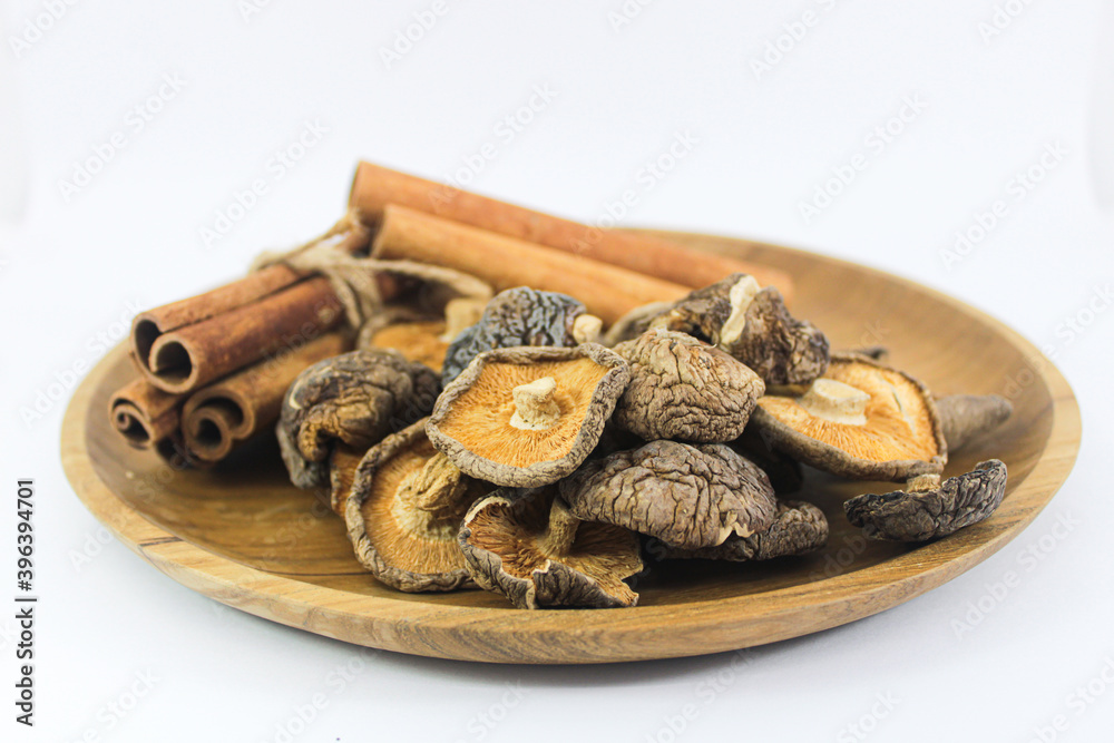 Close up Shitake Mushroom and Cinnamon in wood plate Close up Shitake Mushroom and Cinnamon in wood plate