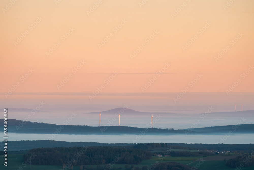 Rhöner Kuppenl im Nebel mit Morgenrot und Windkraftanlagen