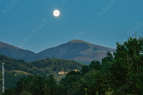 The Moon rising between the mountains at dusk © roberto