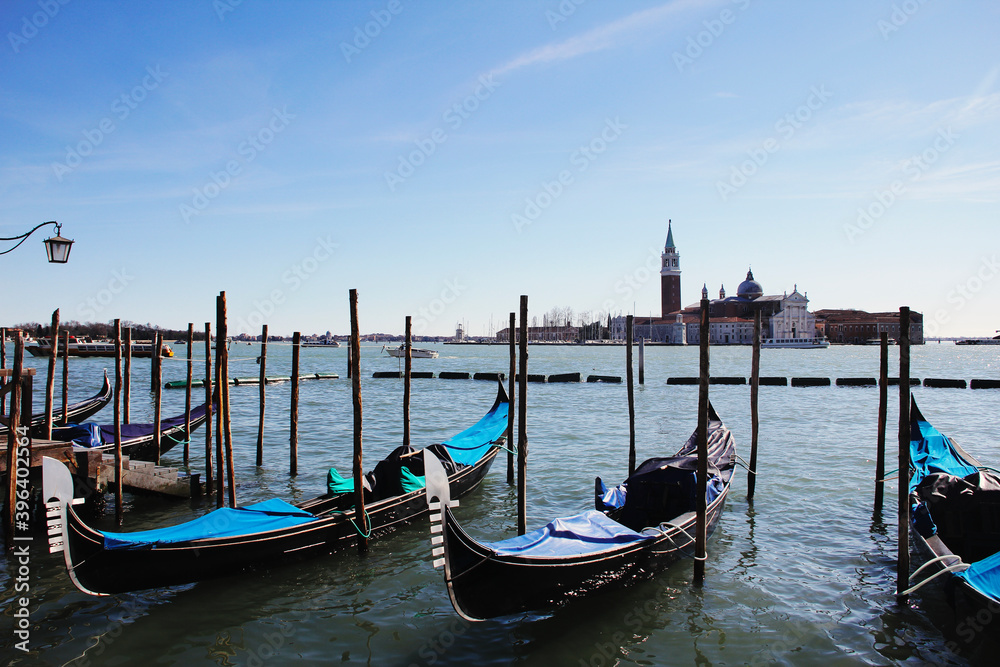 ITALY, VENICE - February 28 2017: typical gondolas of Venice and the church of San Giorgio Maggiore in the background