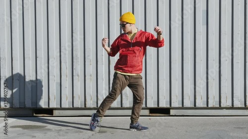 Dancing man funny break dance, happy rhythmically waving his arms against grey textured street wall. Playful crazy man dance emotions. Breakdancing, street dancing, hiphop, freestyle dance. Lifestyle 