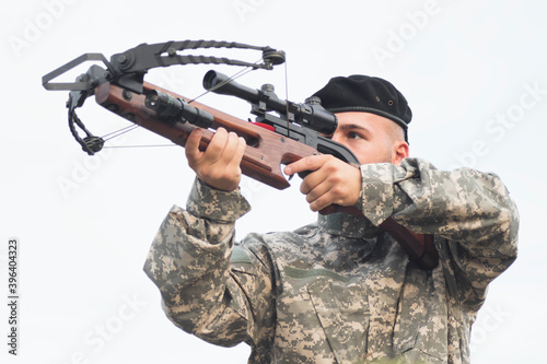 army soldier shooting a crossbow weaopn
