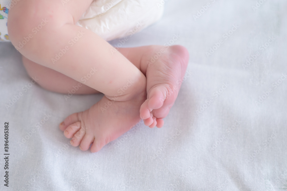 closeup of newborn baby feet on a white blanket with selective focus on the closest foot closeup of newborn baby feet on a white blanket with selective focus on the closest foot