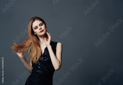 Beautiful woman in black dress red hair gray background Copy Space Model