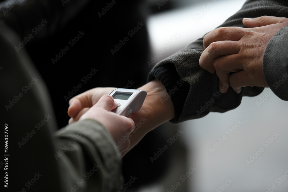 Visitors must go through fever measures using infrared digital thermometer check temperature measurement, fever examination at the building.Measures to prevent people with fever,Corona virus,Covid-19.